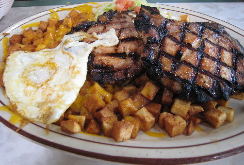 Grilled pork chops, papitas and a fried egg