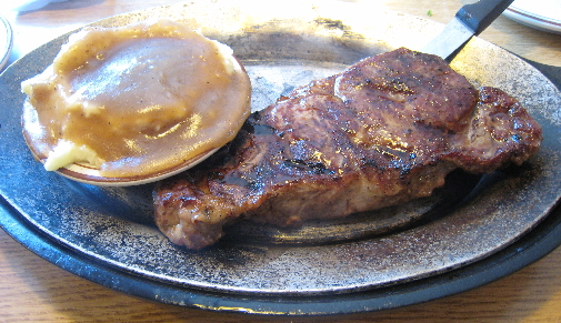 New York steak with mashed potatoes and gravy.