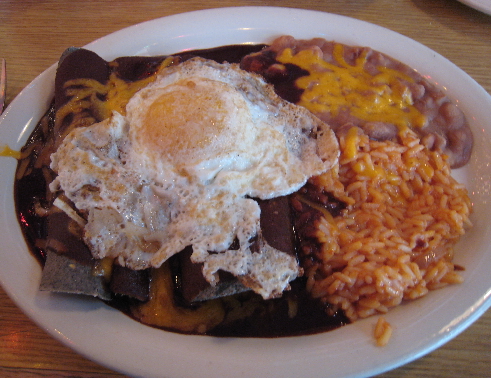 Blue corn enchiladas with red chile and a fried egg