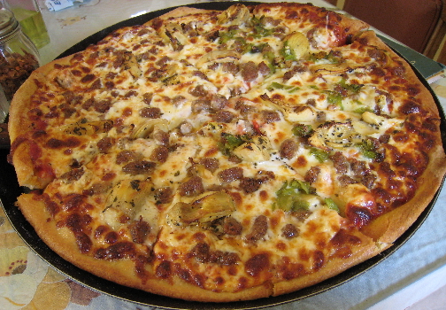 Pizza with artichoke hearts, green chile, sausage, onions.